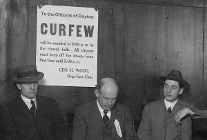 Men sitting near a curfew sign in Dayton just after the flood (cropped from ms128_3-8-25)