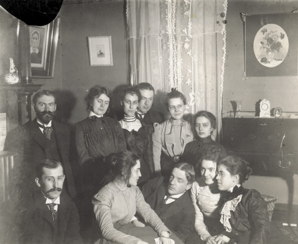 Party in the parlor of the Wright home at 7 Hawthorne Street, 1906. Top row, left to right: Dr. C. C. McClean, Mary Emmons, unidentified, unidentified, Mrs. McClean, and unidentified.. Bottom row: Orville Wright, unidentified, Nelson Emmons, Agnes Osborne, and Katharine Wright. (photo ms1_29_3_2)