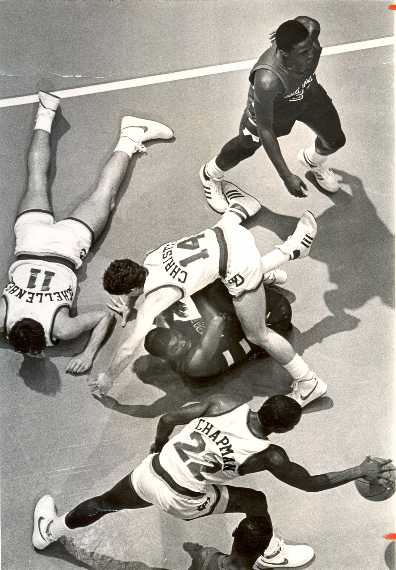 Feb. 24, 1984. UD vs. DePaul. The battle for a loose ball as the game drew to a close found DePaul's Kevin Home, #34, being run over by Dan Christie, while Larry Schellenberger lay sprawled on the floor and Roosevelt Chapman, bottom, comes up with the ball...at the top right is DePaul's Tony Jackson. 