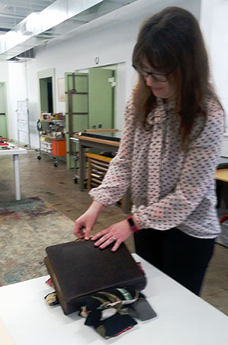 Conservator Laura Moeller opening the treated Wright Family Album.