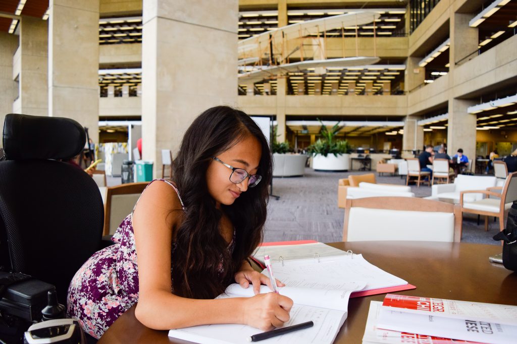 Photo of a library user studying in the 2nd floor atrium.