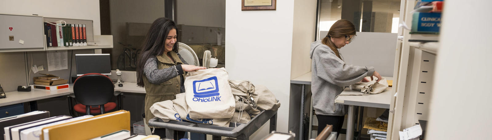 photo of two student employees unloading books